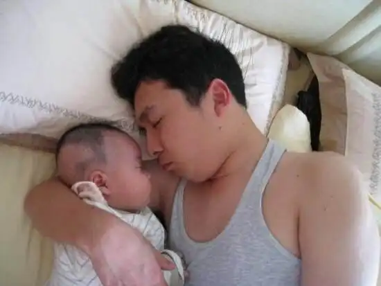  爸爸搂着宝宝睡觉,宝宝对着妈妈招手示意一块来睡,小表情萌翻了